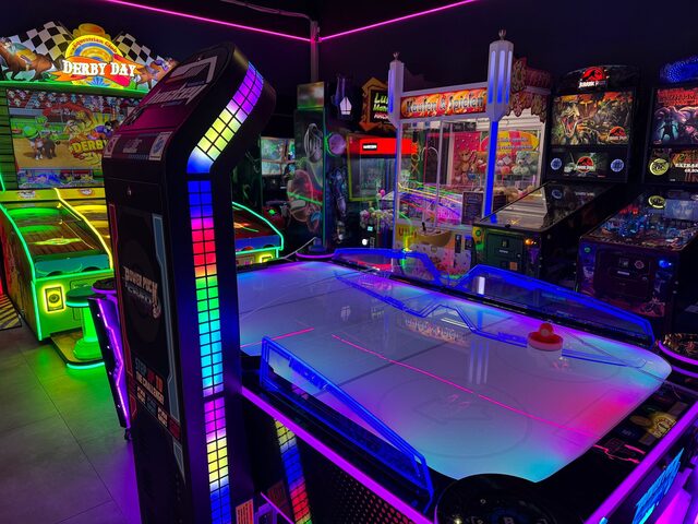 Derby Day Spielautomat neben Air-Hockey-Tisch mit LED-Beleuchtung