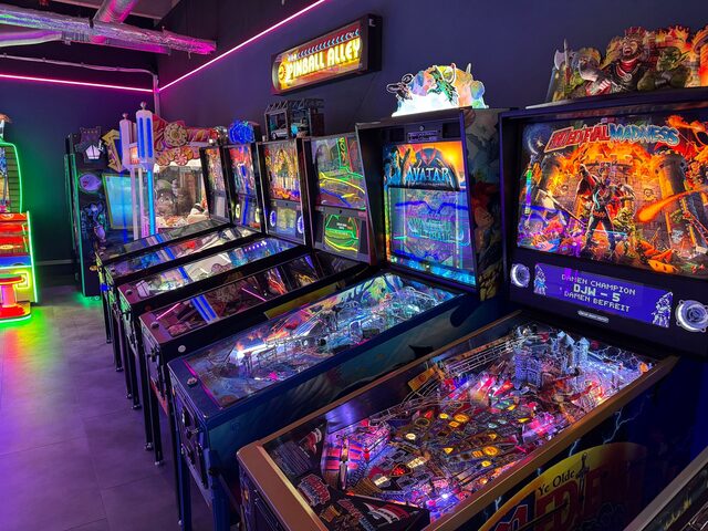 Reihe von Pinball-Maschinen unter der „Pinball Alley“ Leuchtreklame