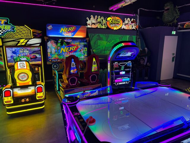 Nerf-Schießstand und Rennspiel-Automaten neben Air-Hockey-Tisch